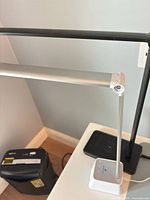 Full view of desk lamp arm, support, and wireless charging pad