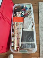 Overview of contents inside clear tote showing rolls, bows, tissue, boxes