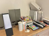 Overall view showing magazine holders, binders, folders, stapler and hole punch on countertop