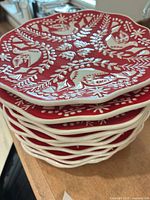 Stack of red and white embossed plates showing top design