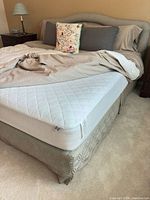 Full view of assembled queen bed showing mattress, box spring, headboard, bedskirt