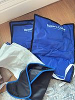 Two blue Rester's Choice gel packs, white elastic strap, black neoprene wrap
