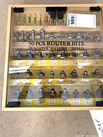 Top view of case showing contents and printed "50 PCS ROUTER BITS" text
