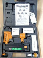Open carrying case showing Bostitch nailer, manual, lubricant, two fastener boxes