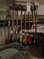 Six mallets hanging on rack with coloured balls beneath