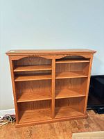 Front view of oak double bookcase showing shelves and divider