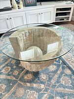 Full view of table showing glass top and travertine base