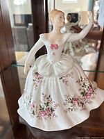 Front view of porcelain ballerina figurine displaying full skirt and floral design