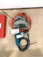 Skilsaw circular saw with orange cord and Makita drywall screwdriver shown together