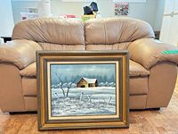 Front view of loveseat with painting leaning against it