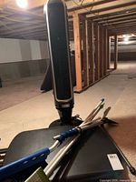 Tower fan standing behind folded table and cleaning tools