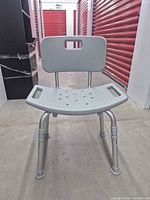 Front view of adjustable shower chair showing seat, backrest, and legs