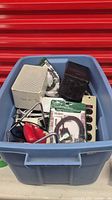Blue tote holding speakers, Wi-Fi extender pouch, surge protector, red mouse, cables