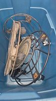 Metal trays and dolly parts inside blue bin
