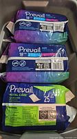 Three Prevail product packs stacked: two Air Daily Briefs 18-count, one Total Care Underpads 25-count