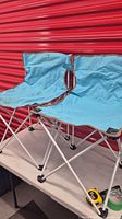 pair of light blue folding camping chairs on table