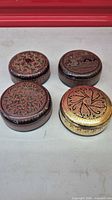 All four round lacquered boxes grouped