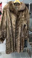 Front view of full-length mink fur coat on hanger