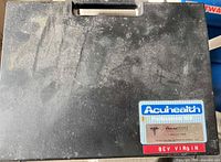 Exterior of black carrying case showing Acuhealth Professional 900 label and surface wear