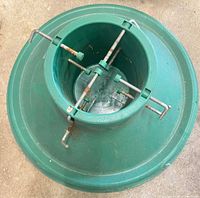 Top view of green plastic tree stand showing four metal adjustment screws