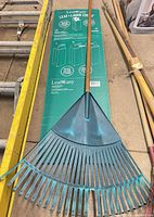 Full view of LeafEasy rake showing teal plastic head and full length wood handle