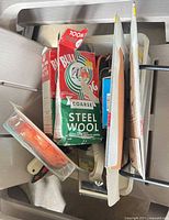 Bin containing steel wool boxes, sandpaper, paint tools, scrapers