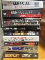 Spine view of all nine paperback novels stacked