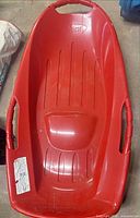 Top view of red Pelican sit-on sled showing seat, handles, overall condition