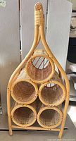 Front view showing five cylindrical wicker holders within rattan frame