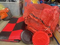 Checker pieces, mesh bag and rolled checkerboard mat grouped together