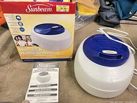 Humidifier unit, power cord, box and manual on tabletop