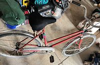 Full left-side view of red Supercycle step-through bicycle with fenders and 27-inch wheels