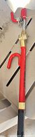 Full view of red steering wheel lock bar with hooks and brass lock housing