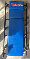 Top view showing full length blue vinyl surface, black frame, Westward logo