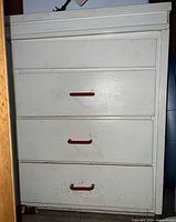 Front view of white 4-drawer dresser with red handles