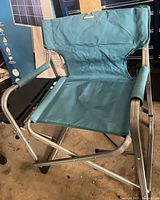 Front view of one Woods teal folding director’s chair showing seat, backrest and frame