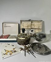 Group shot of all items: plunger ashtray, playing cards, forks box, sword picks, Paris ashtray, Nuss Wal dispenser