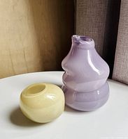 Purple and yellow glass vases on round table