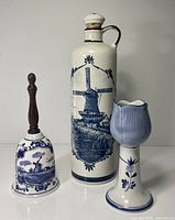 Full view of three Delft Blue pieces: bottle, bell, candlestick