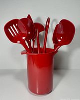 Pitcher holding six red utensils