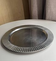 Angled view showing ribbed rim and flat surface of aluminum tray