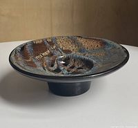 Oblique view showing bowl profile, footed base and glaze pattern