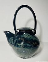 front view of teapot showing overall form, handle, spout, glaze
