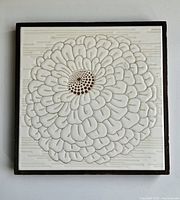 Front view of framed ceramic tile with raised flower design