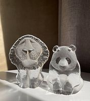 Lion and panda glass figurines side by side