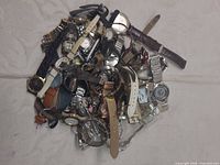 Pile view showing mixture of wristwatches, straps and loose parts