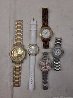 All five watches laid out to show variety of styles and finishes