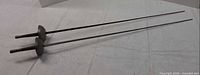 Two full-length swords side by side on flat surface