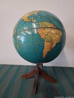 Full view of globe on wooden tripod stand