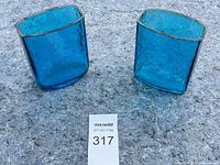 Two square blue textured glass vases on carpet, lot number card visible